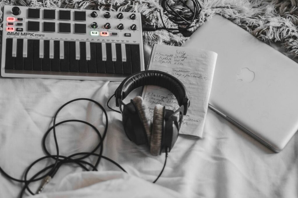 A tidy home-studio desk with a MIDI keyboard, headphones, and a notebook ready for practice and editing.