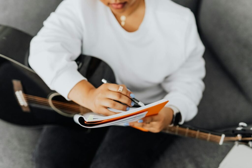 A musician practicing a short passage while a notebook sits open nearby.