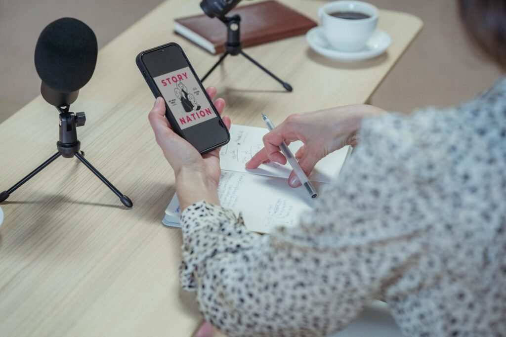 A phone on a small tripod beside a notebook of talking points and a timer.