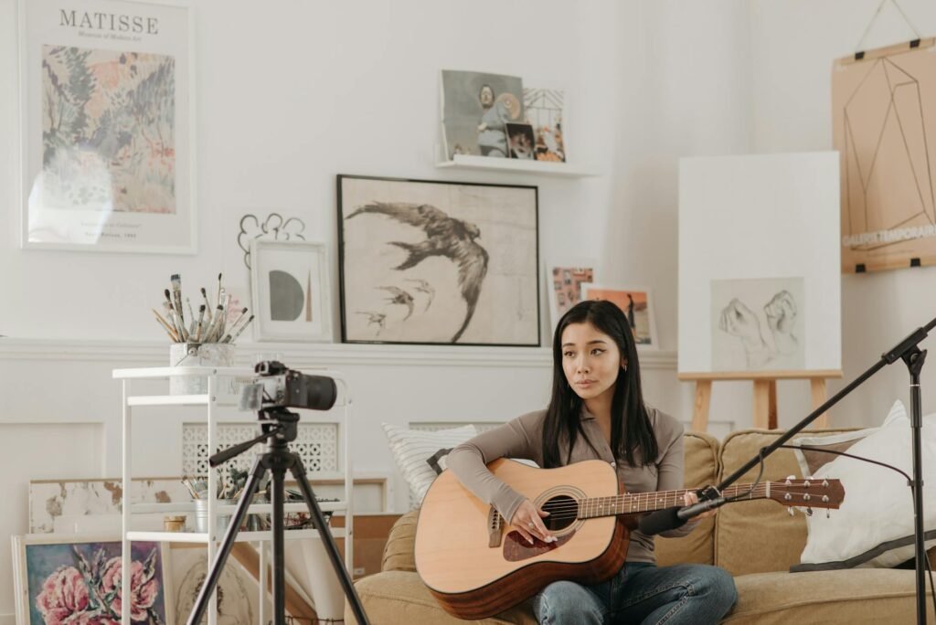 A musician recording a practice rep with a phone on a tripod