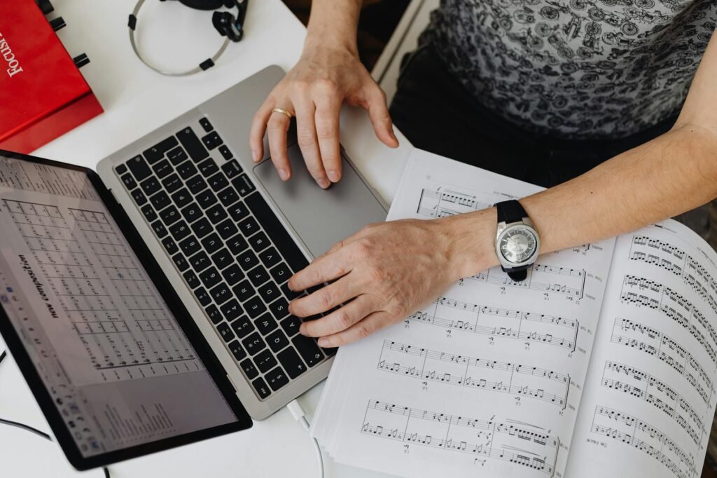 A tidy music practice setup with sheet music, a metronome, a pencil, and a timer on a desk