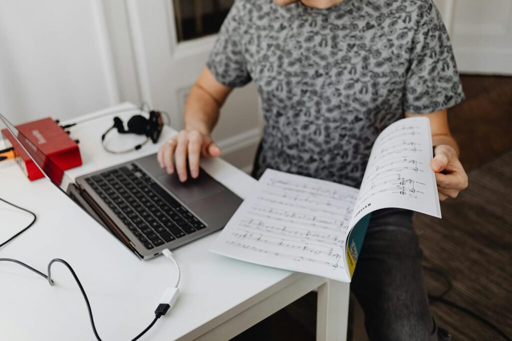 A checklist notebook beside sheet music and a phone ready to record a rehearsal take