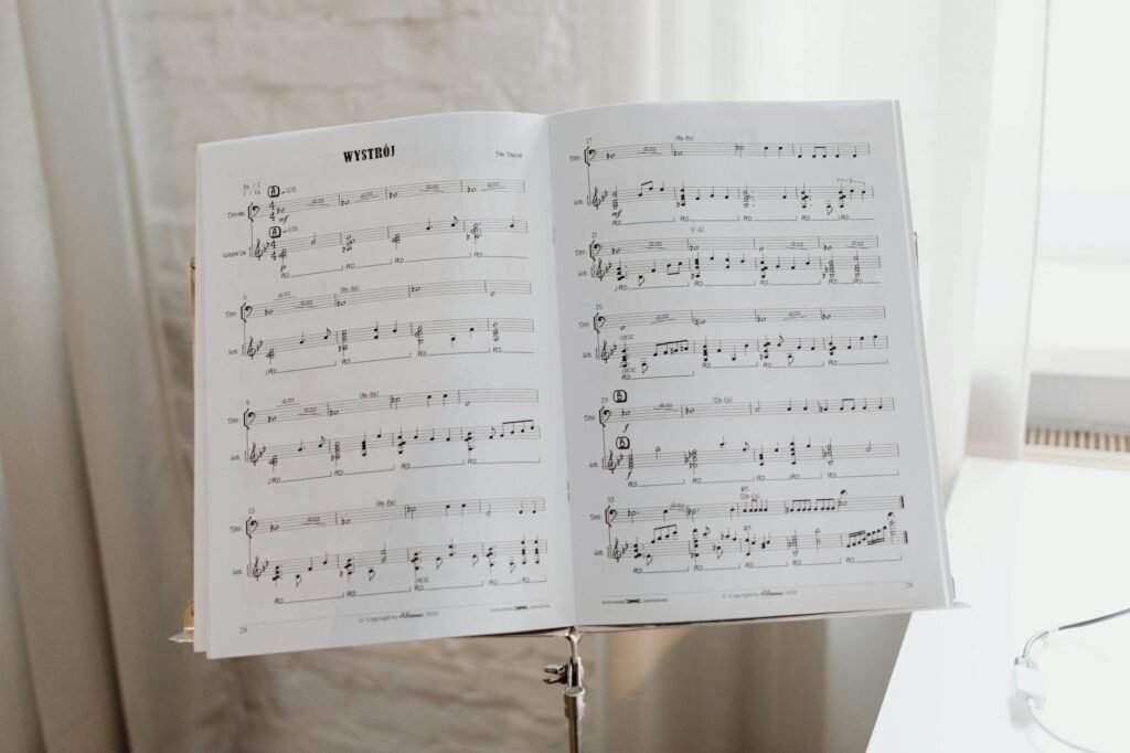 An organized practice desk with a timer, notebook, pencil, and printed music.