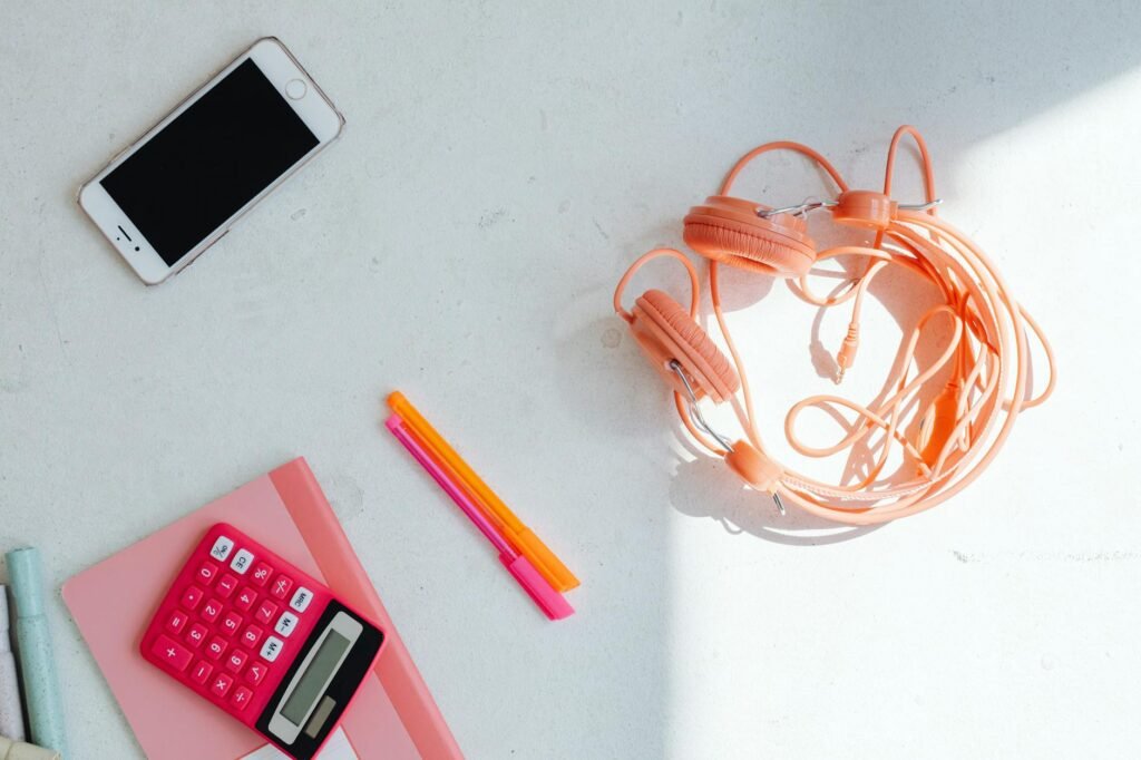 A tidy practice workspace with a notebook, headphones, and a phone set up to record