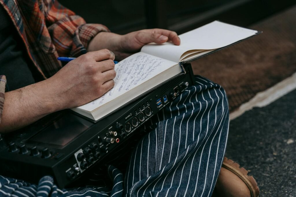 A musician writing brief practice notes in a notebook during a timed break