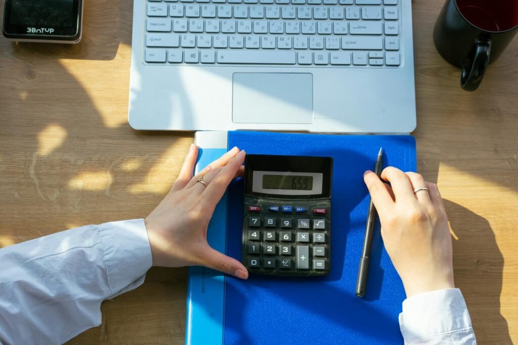 A notebook with timing notes and a calculator beside a small keyboard on a desk.