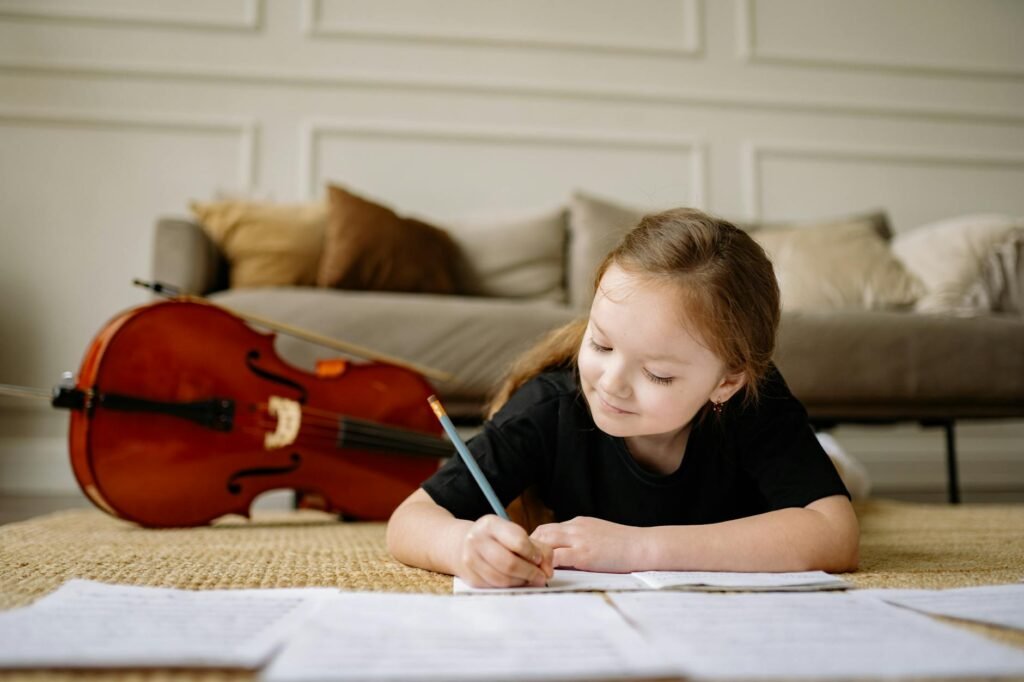 Metronome, notebook, and pencil arranged beside an instrument in a practice room