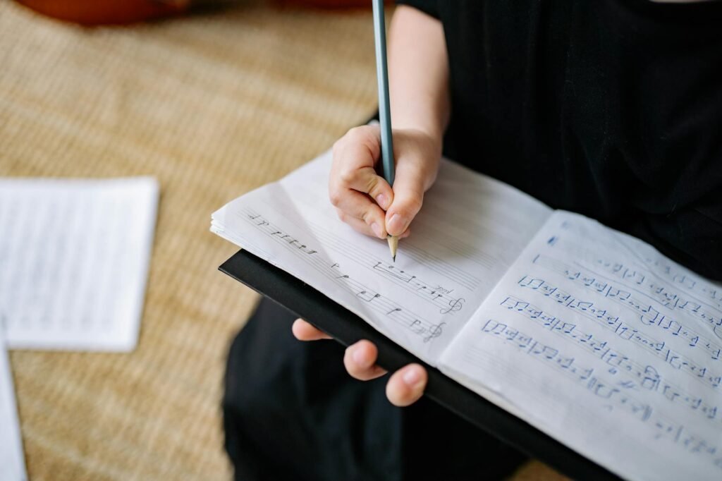 A metronome beside marked sheet music and a pencil on a practice desk