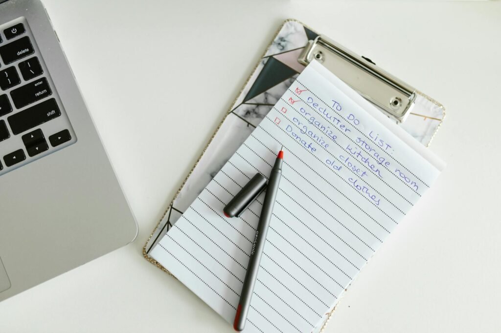 A handwritten practice checklist next to a laptop and coffee mug on a desk.