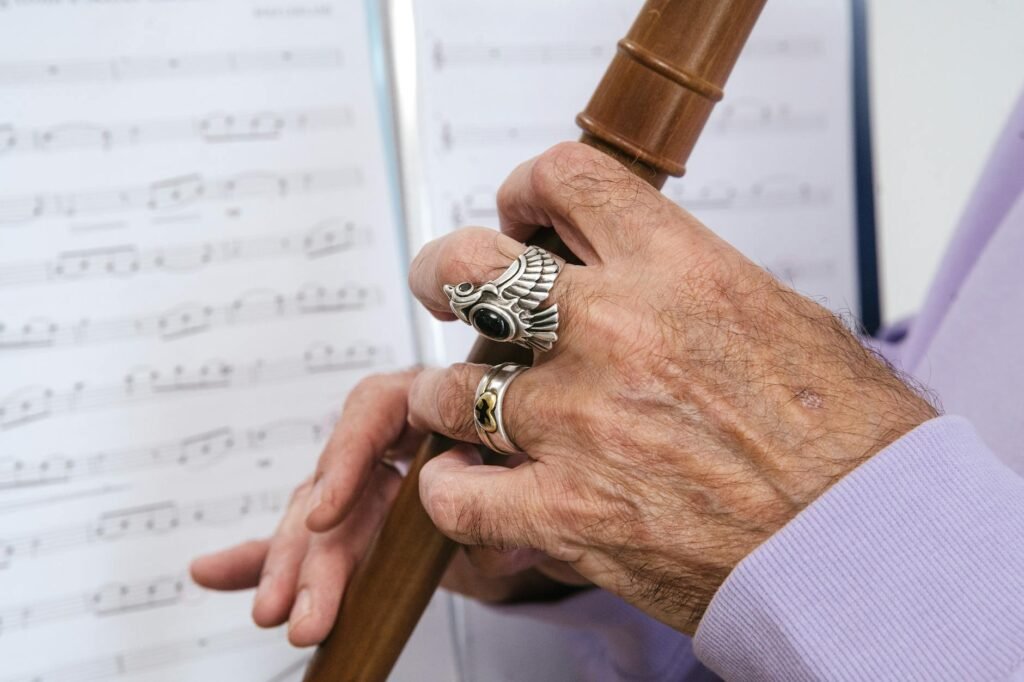 Hands using a pencil to mark technical notes on printed sheet music
