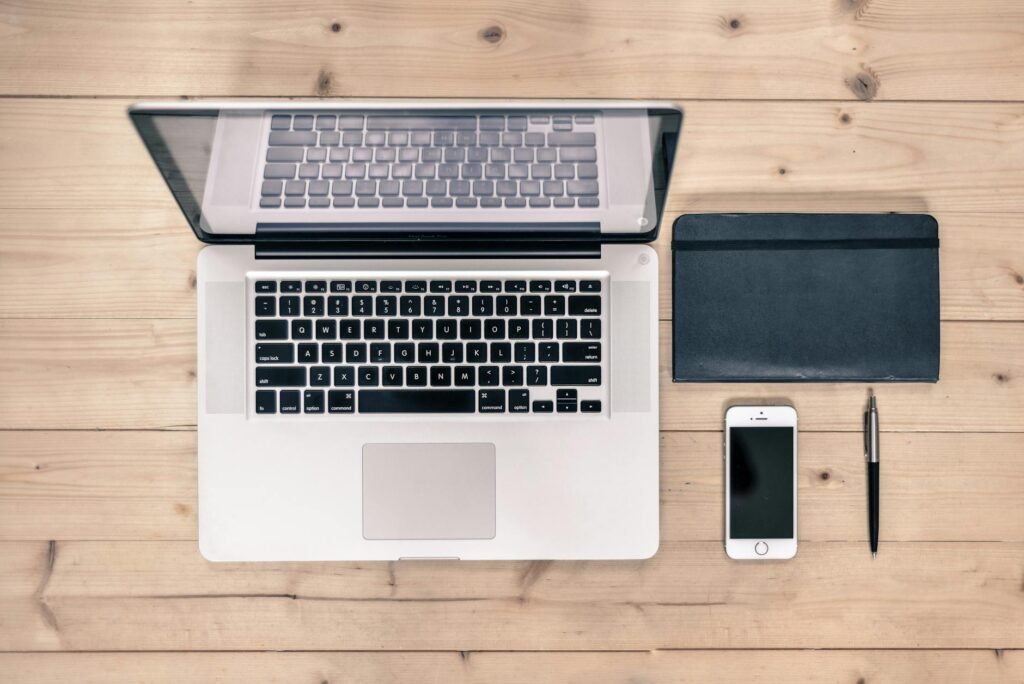 A tidy desk with a laptop, notebook, pen, and timer ready for a focused practice session.