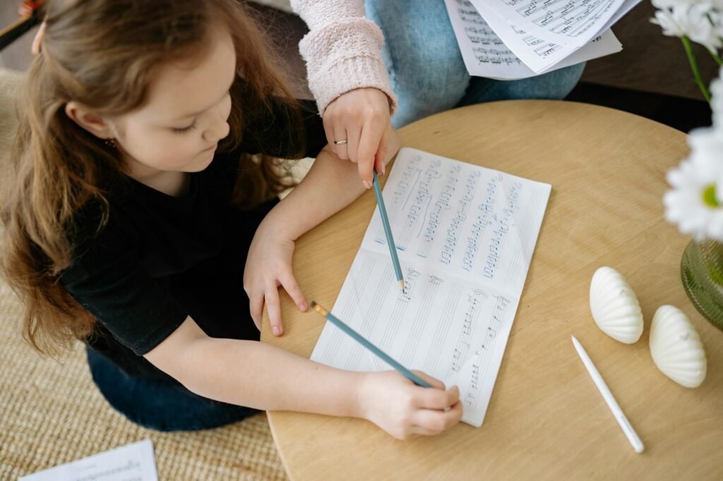 Annotated sheet music on a music stand with a pencil and metronome nearby